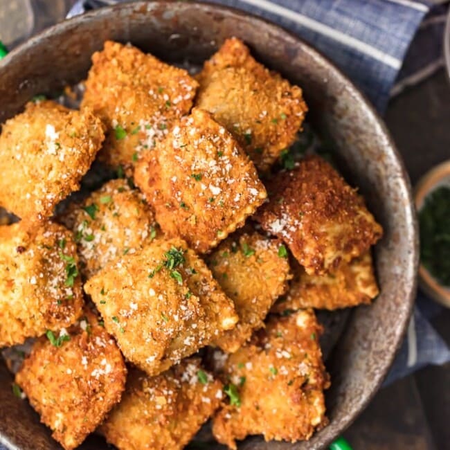 Fried calamari topped with parmesan cheese in a sizzling pan.