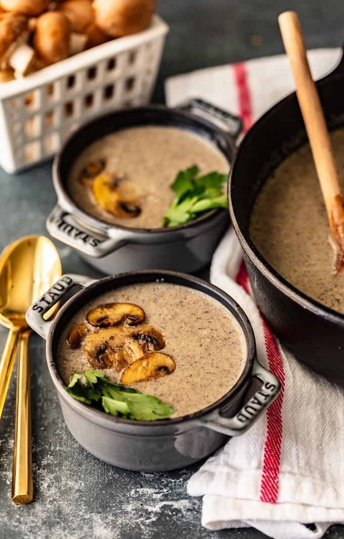 Two bowls of cream of mushroom soup topped with sliced mushrooms