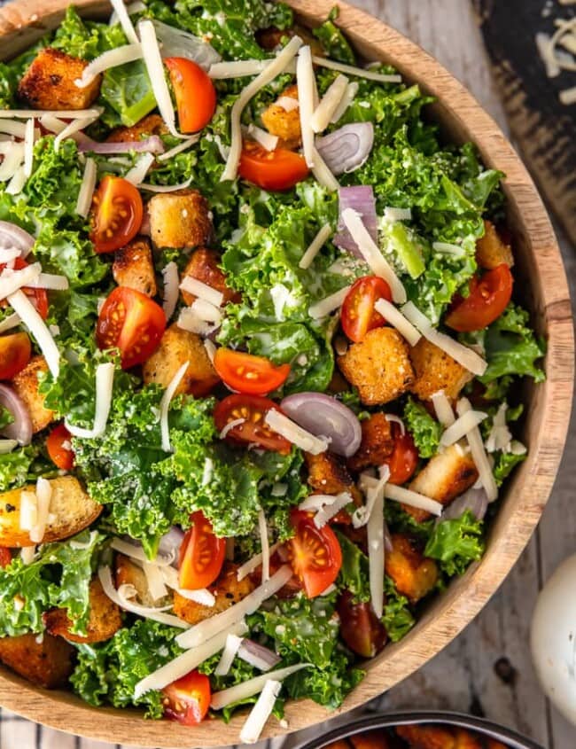 Kale Caesar Salad is the perfect side salad for any meal! It's just like a classic caesar salad, but with a twist. You've got the homemade croutons and the caesar dressing, but we're throwing in kale instead of romaine, and adding some tomatoes and shallots for extra flavor. This salad recipe is good!