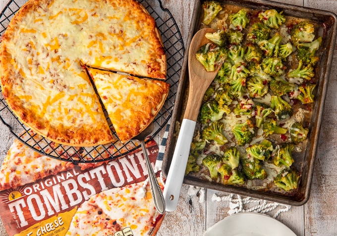 cheese pizza on wire rack next to a sheet pan of spicy cheesy broccoli