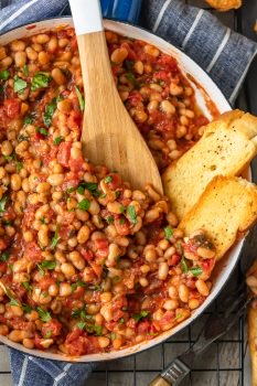 This White Beans recipe is so simple, yet so delicious! Cannellini beans cooked with tomatoes, garlic, and chicken broth make for one tasty side dish. It's perfect for holidays or easy weeknight meals!