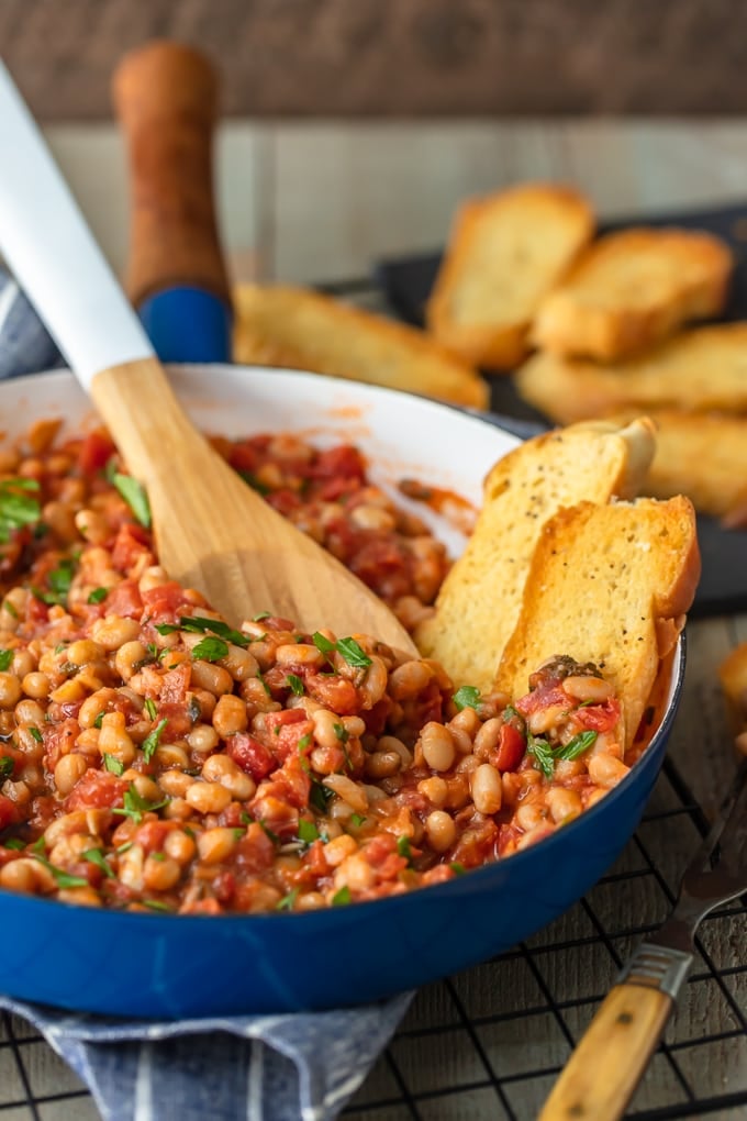 blue skillet filled with white beans and tomatoes