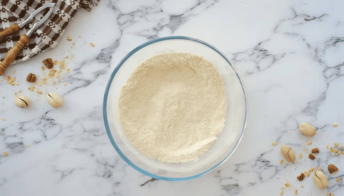 Dry ingredients for morning glory muffins in a glass bowl.