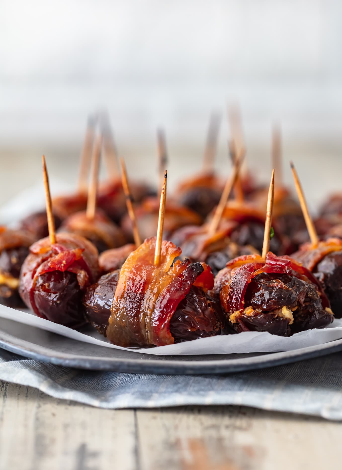 a plate of dates wrapped in bacon with toothpicks