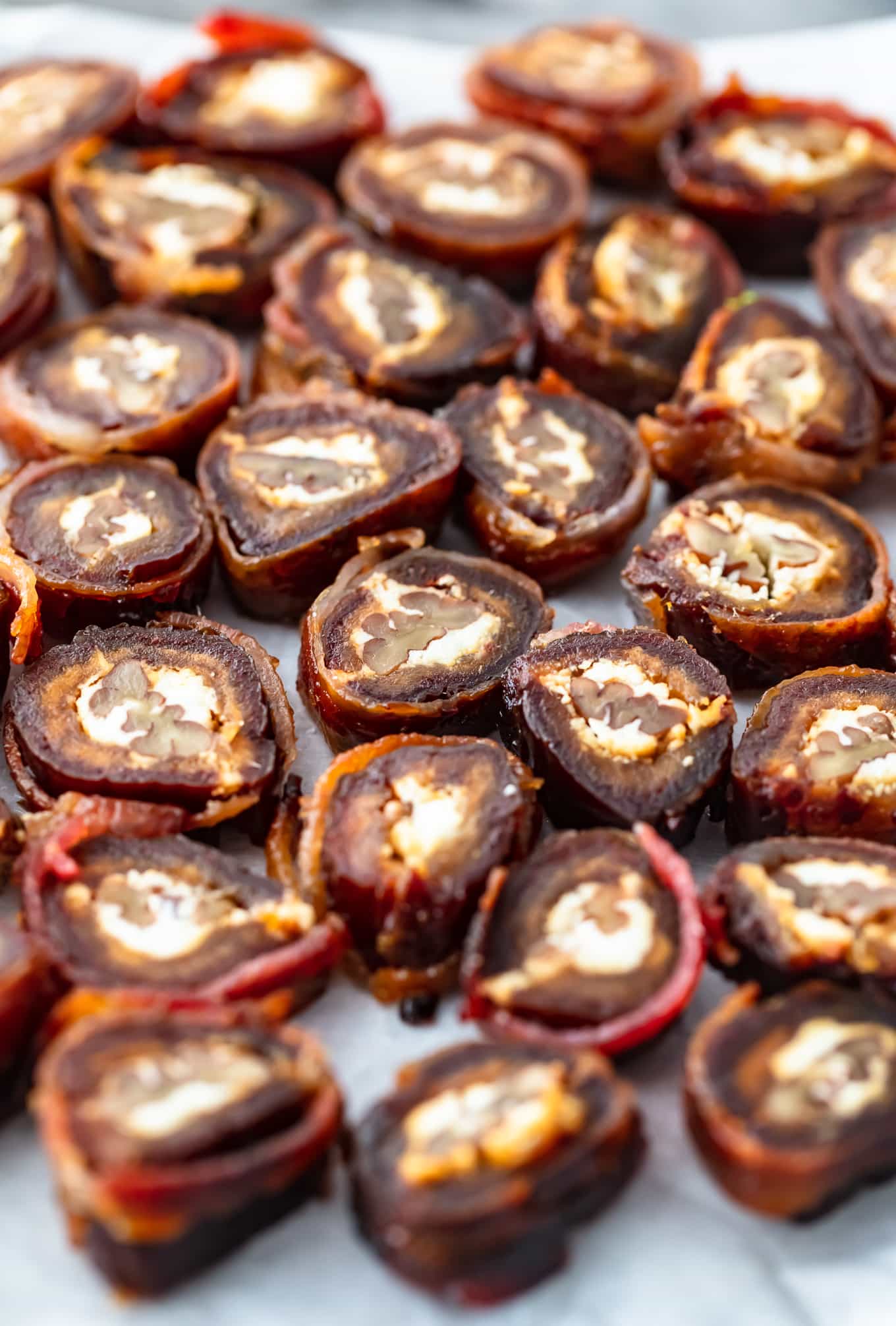 bacon wrapped dates sliced and set on a plate