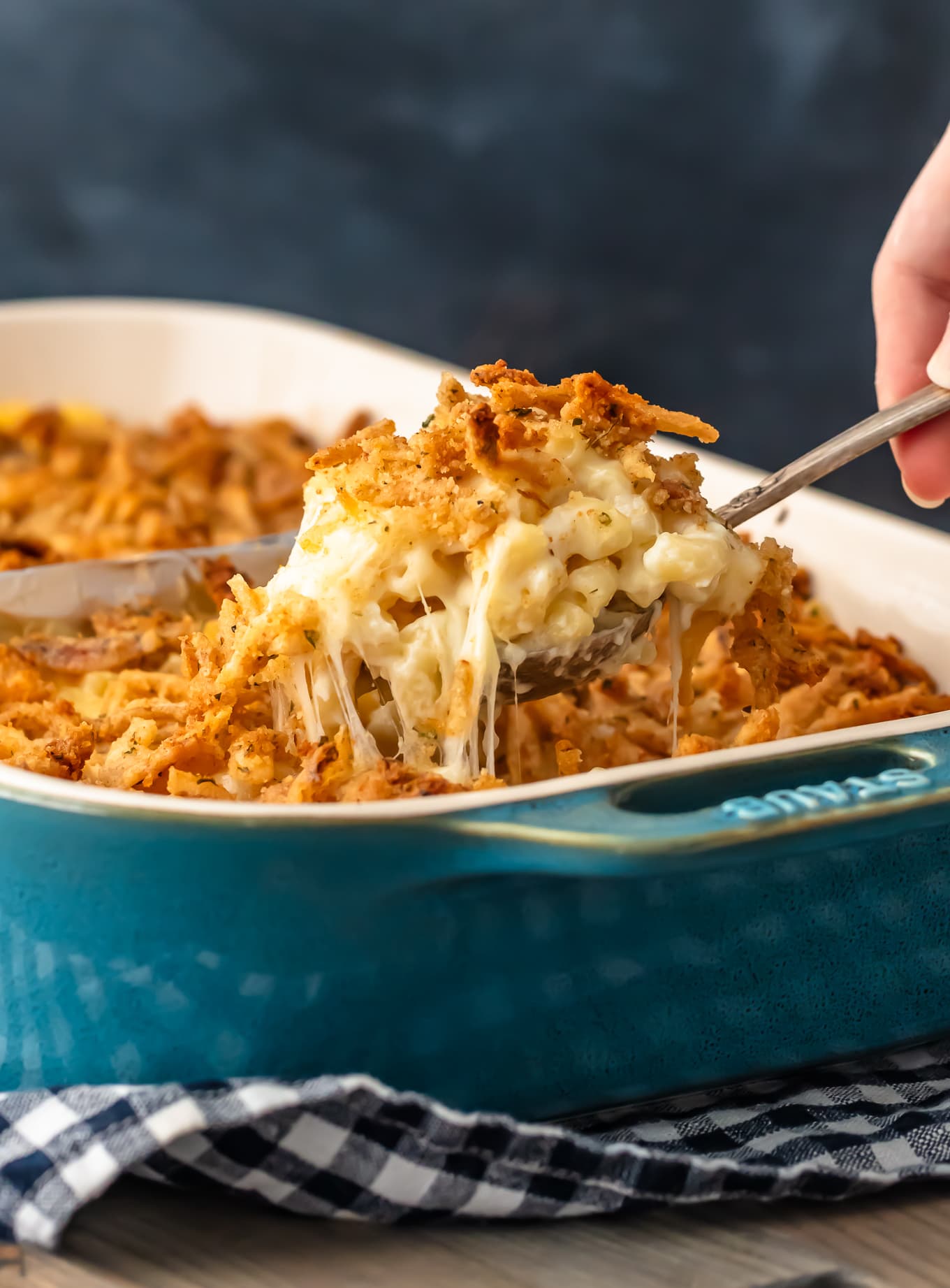 lifting a spoonful of baked mac and cheese casserole