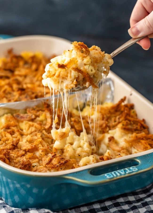 scooping up a spoonful of mac and cheese out of a casserole dish