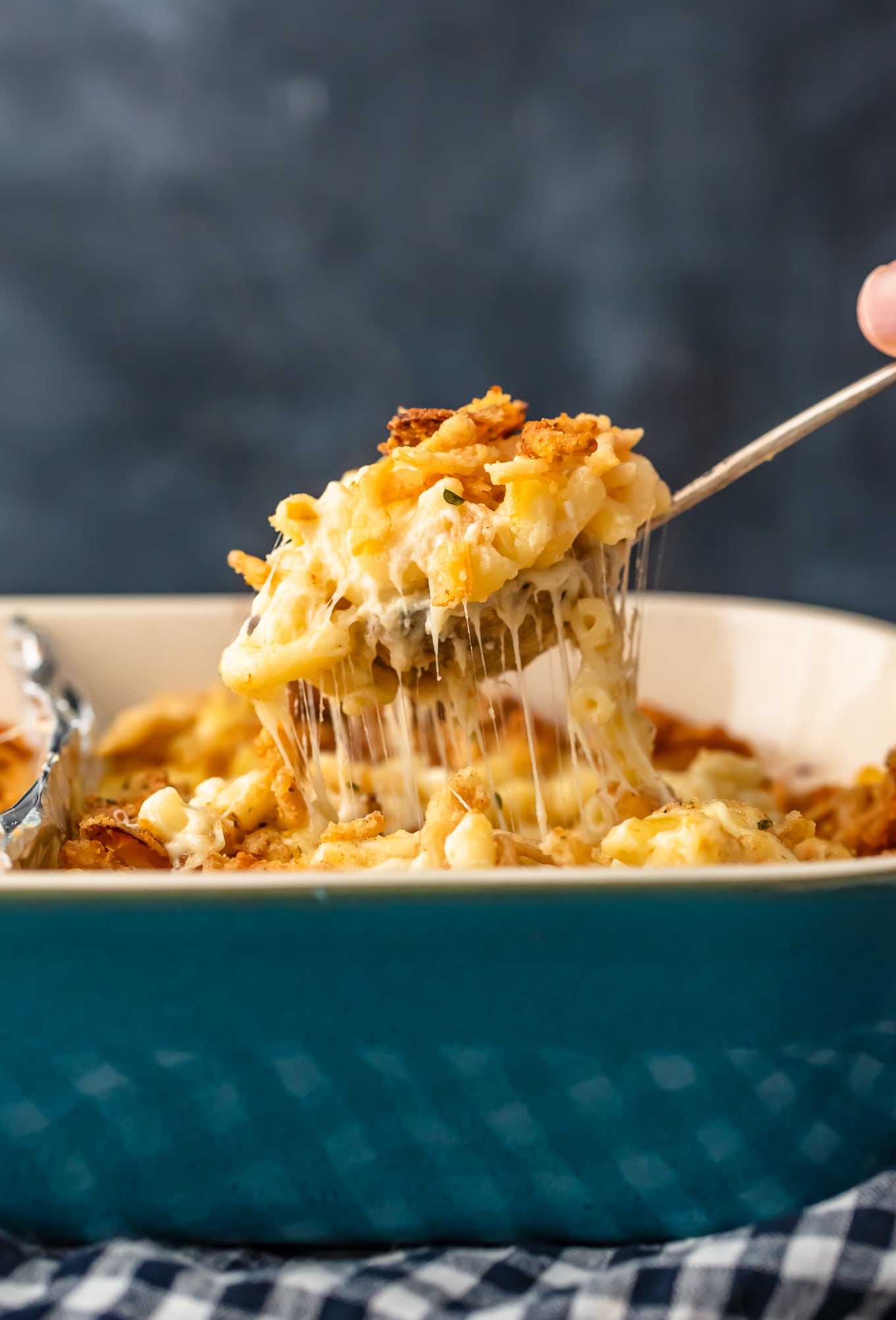 lifting up a spoonful of cheesy baked macaroni and cheese casserole