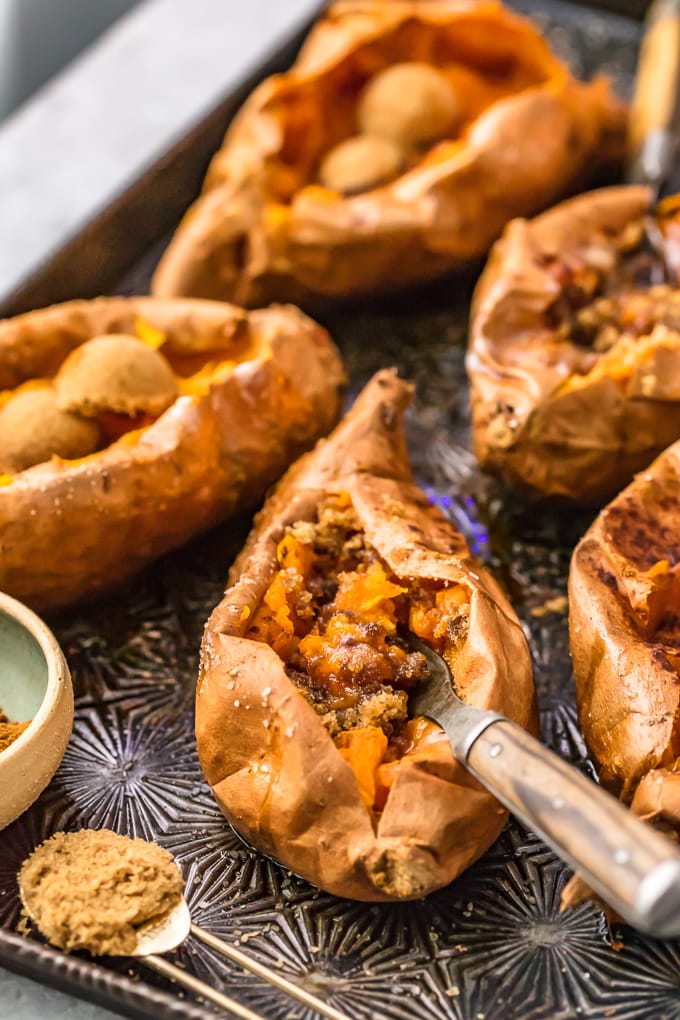 sweet potatoes on a baking sheet, stuffed with brown sugar and cinnamon