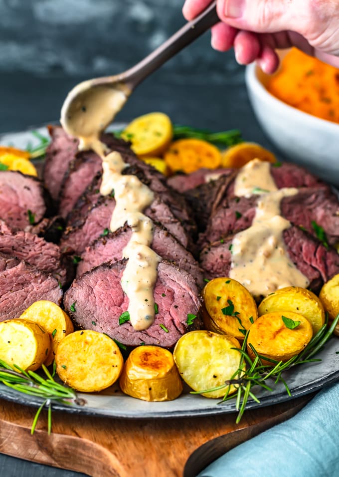 drizzling brand peppercorn sauce over beef tenderloin