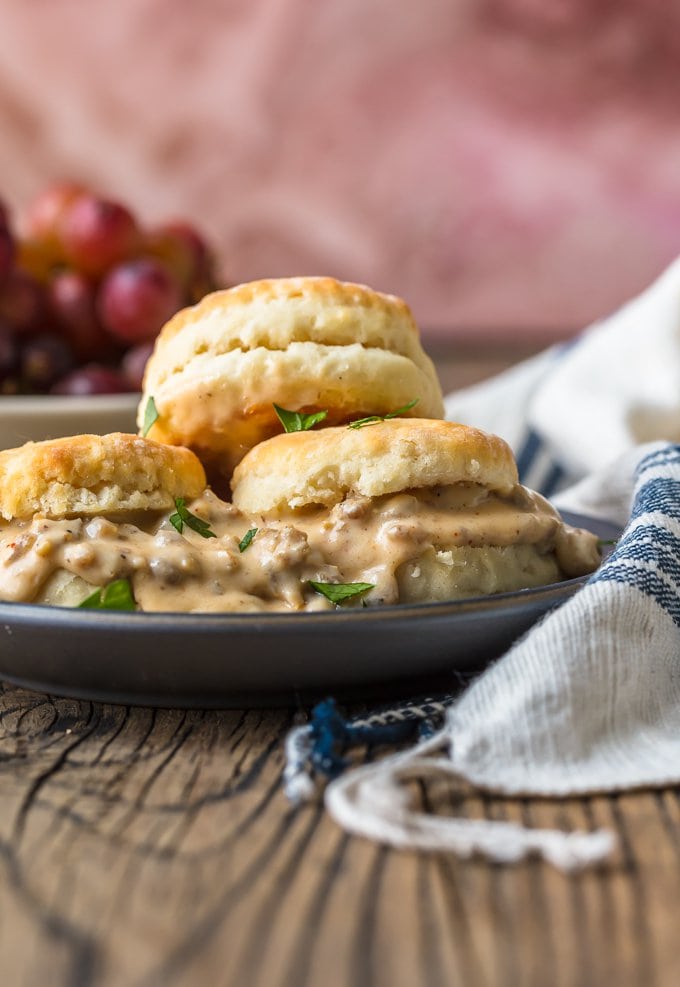 a plate of biscuits and gravy next to a dish towel