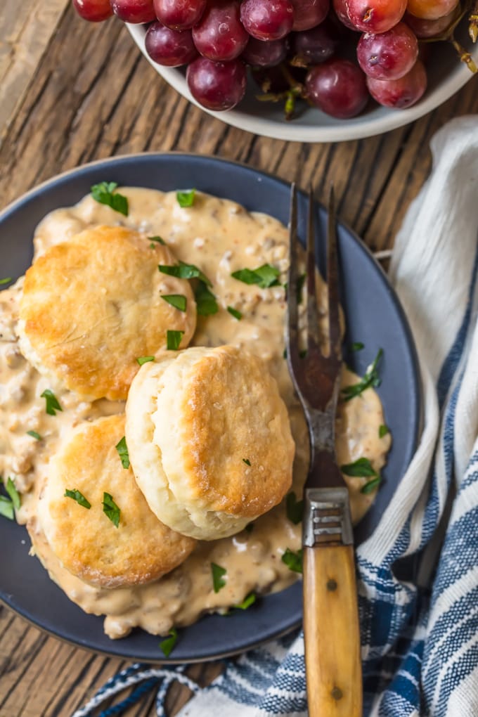 a plate of sausage biscuits gravy with a fork