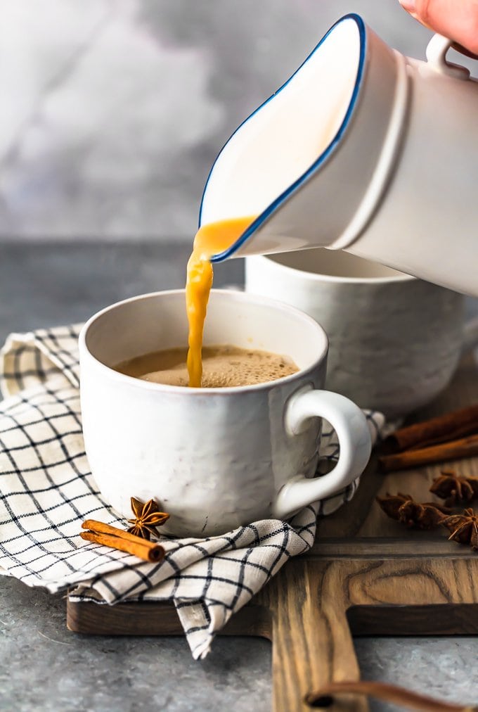 pouring spiced chai tea into a white mug