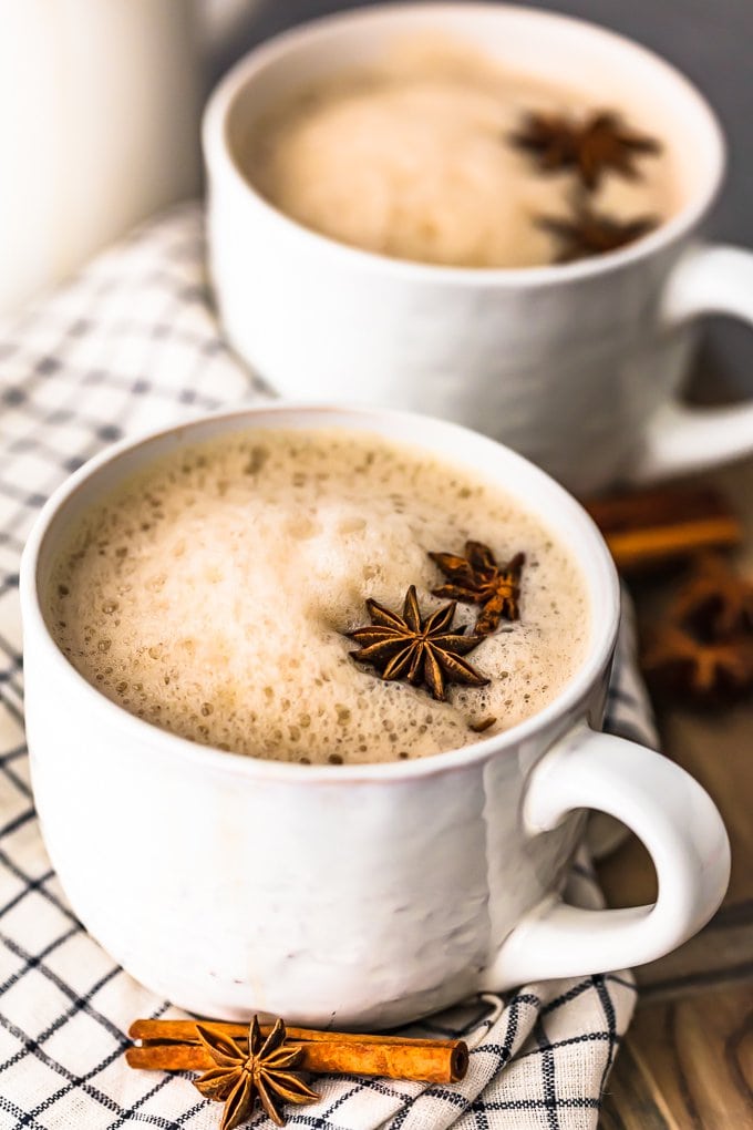 two white mugs of chai topped with anise