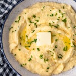 Cheesy Mashed Cauliflower is a healthy (and tasty) alternative to regular mashed potatoes. Learn how to make cauliflower mash with this simple recipe!