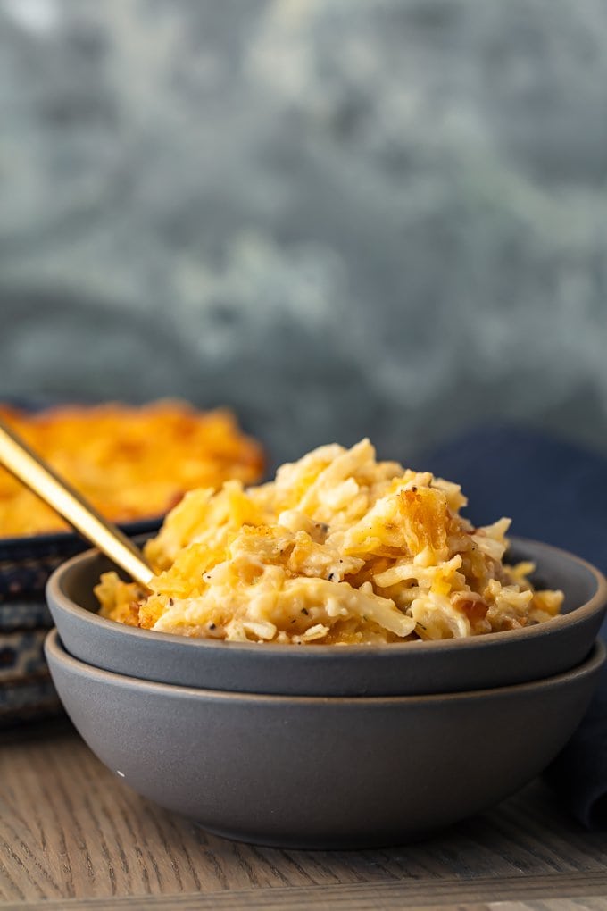 gray bowl filled with cheesy potato casserole