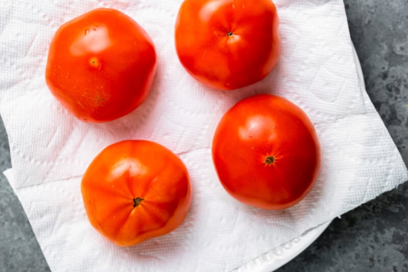 4 tomatoes turned upside down to drain on paper towels.