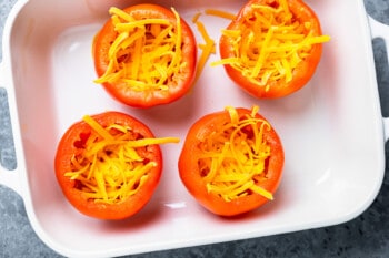 cheese in 4 hollowed out tomatoes in a baking pan.