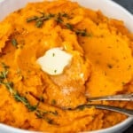 Savory mashed sweet potatoes with sprigs of thyme.