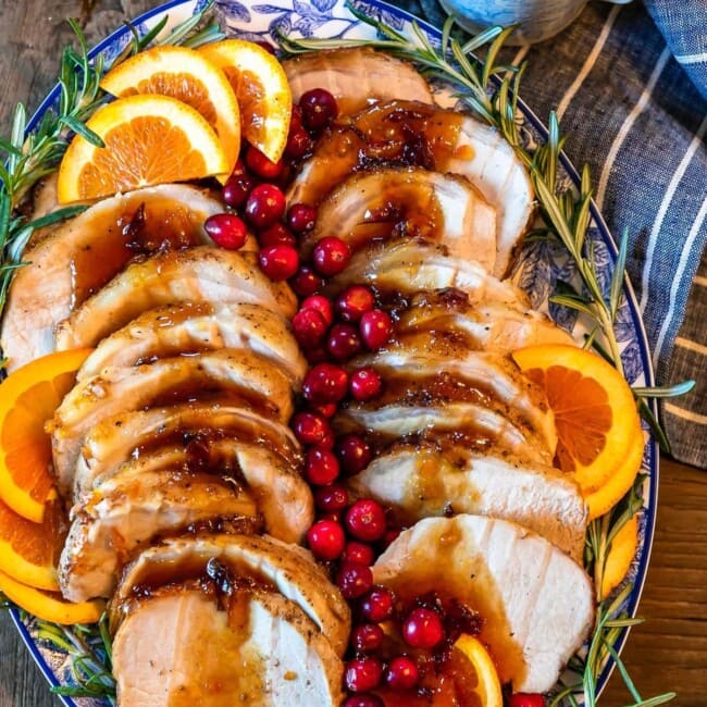 This Pork Loin Roast recipe is the perfect holiday main dish! This Orange Cranberry Pork Loin Roast is juicy, delicious, and super festive. Add this roasted pork recipe to your Thanksgiving and Christmas tables!