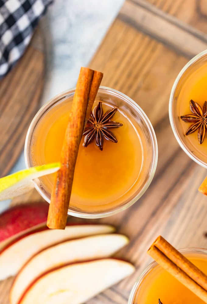 overhead view of a glass of pear cider, with anise and cinnamon sticks