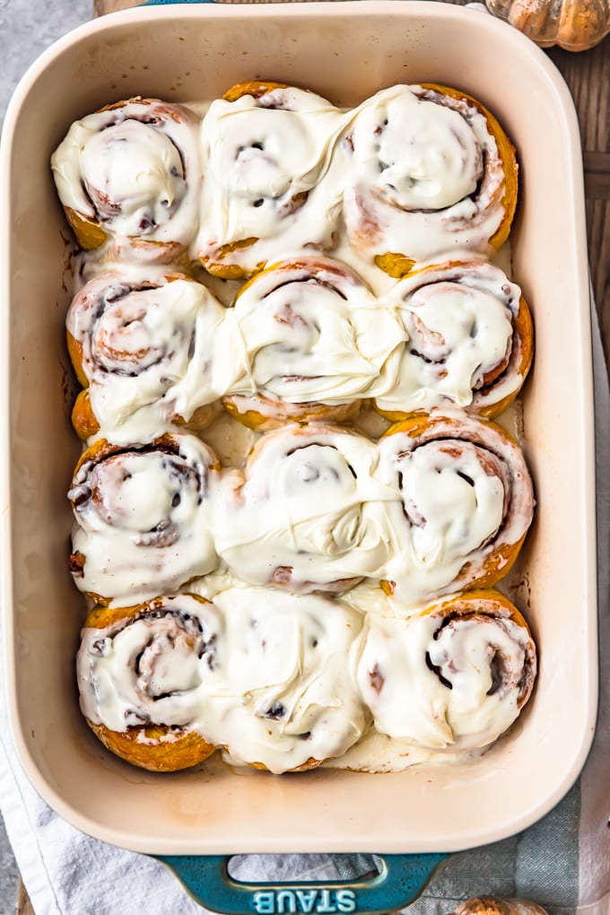 overhead view of pumpkin cinnamon rolls topped with cream cheese frosting