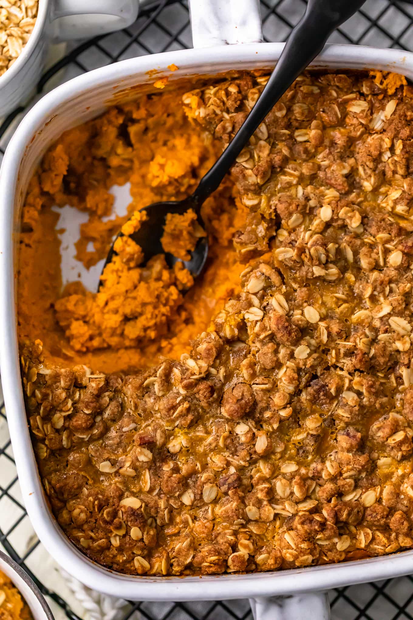 overhead view of pumpkin pie crumble in a white backing dish, with a portion of it removed