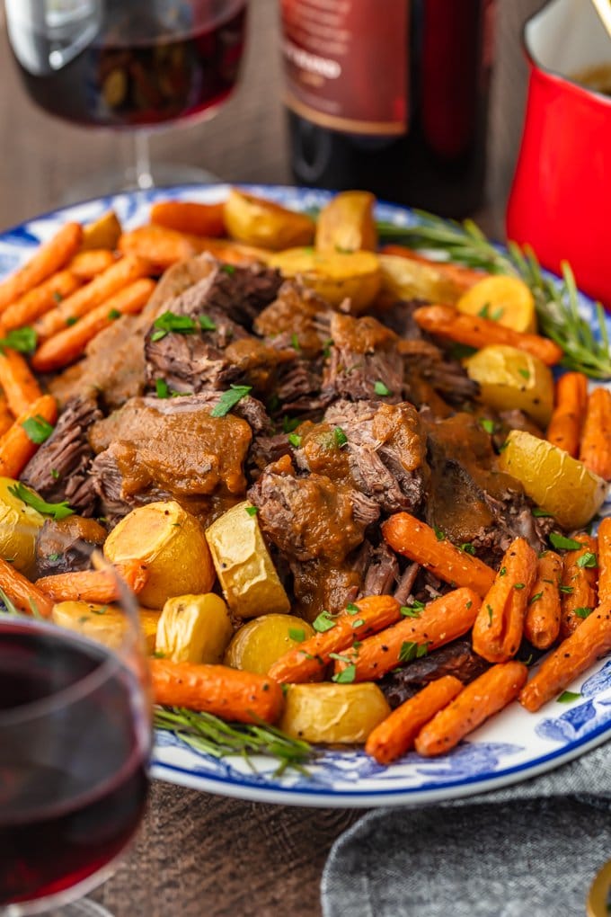 red wine pot roast recipe on a serving platter with gravy and vegetables