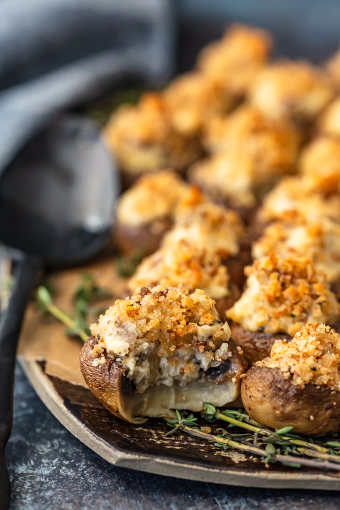 close up on sausage stuffed mushrooms, with a bite taken out of one mushroom