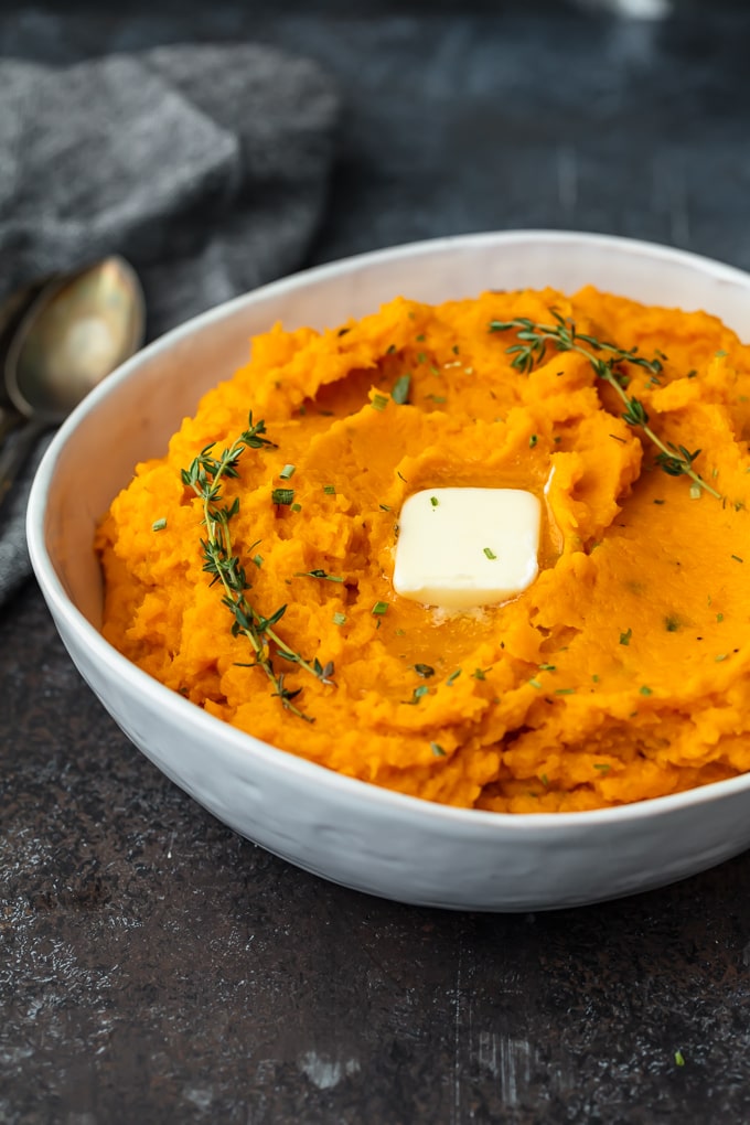 sweet potato mash recipe topped with herbs and butter