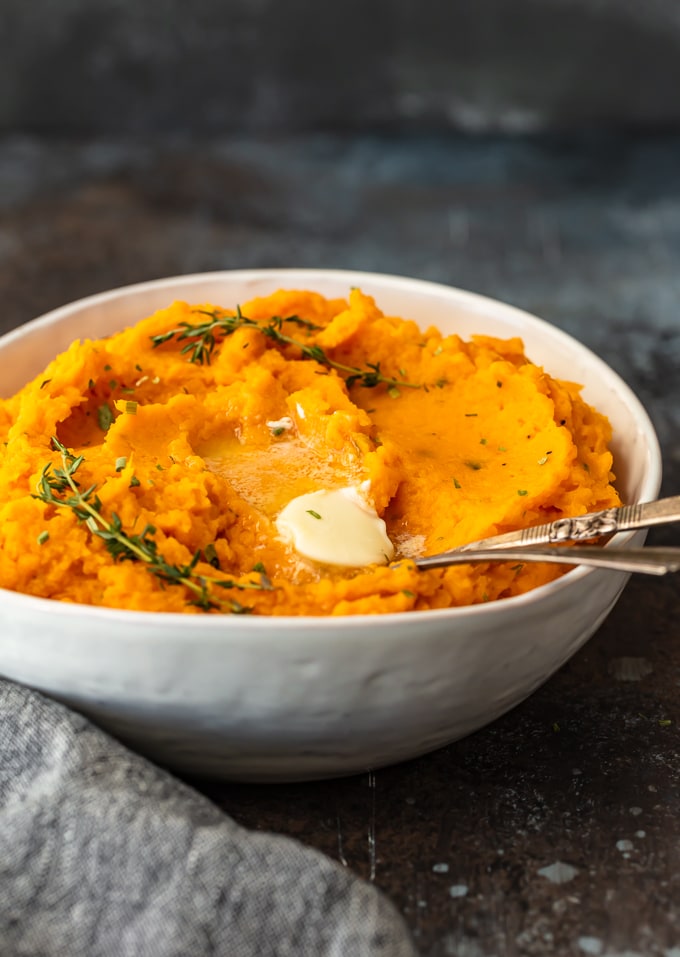 savory mashed sweet potatoes in a white bowl with a spoon