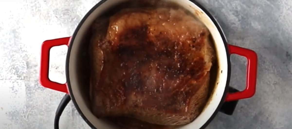 Searing the pot roast in a Dutch oven.