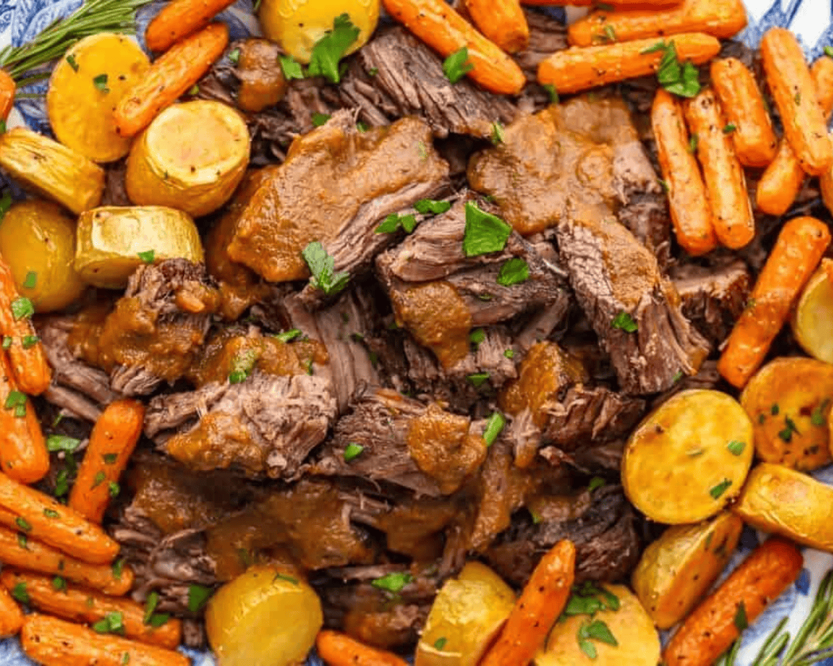 Chunks or red wine pot roast with onions and carrots, garnished with parsley.