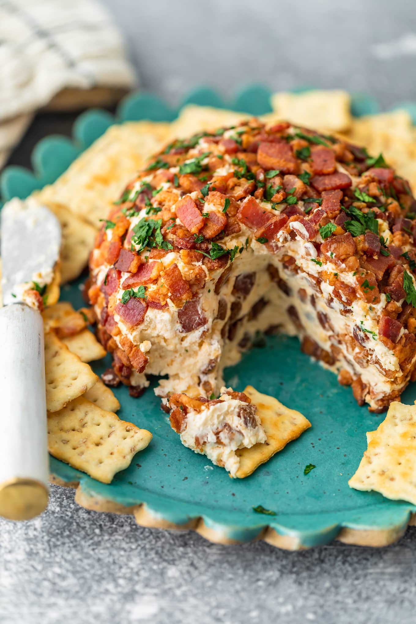 bacon ranch cheese ball on a blue plate with crackers