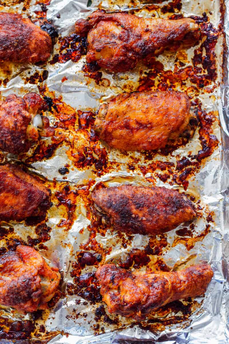 Baked Chicken Wings have the most amazing Chicken Wing Seasoning consisting of paprika, garlic, salt and pepper. If you've wondered How to Bake Chicken Wings that are crispy, flavorful, and amazing, this recipe is for you! EASY Baked Chicken Wings do exist and they're just as delicious, and definitely healthier, when baked and not fried. This is our very favorite Baked Chicken Wings Recipe! baked chicken wings on sheet pan