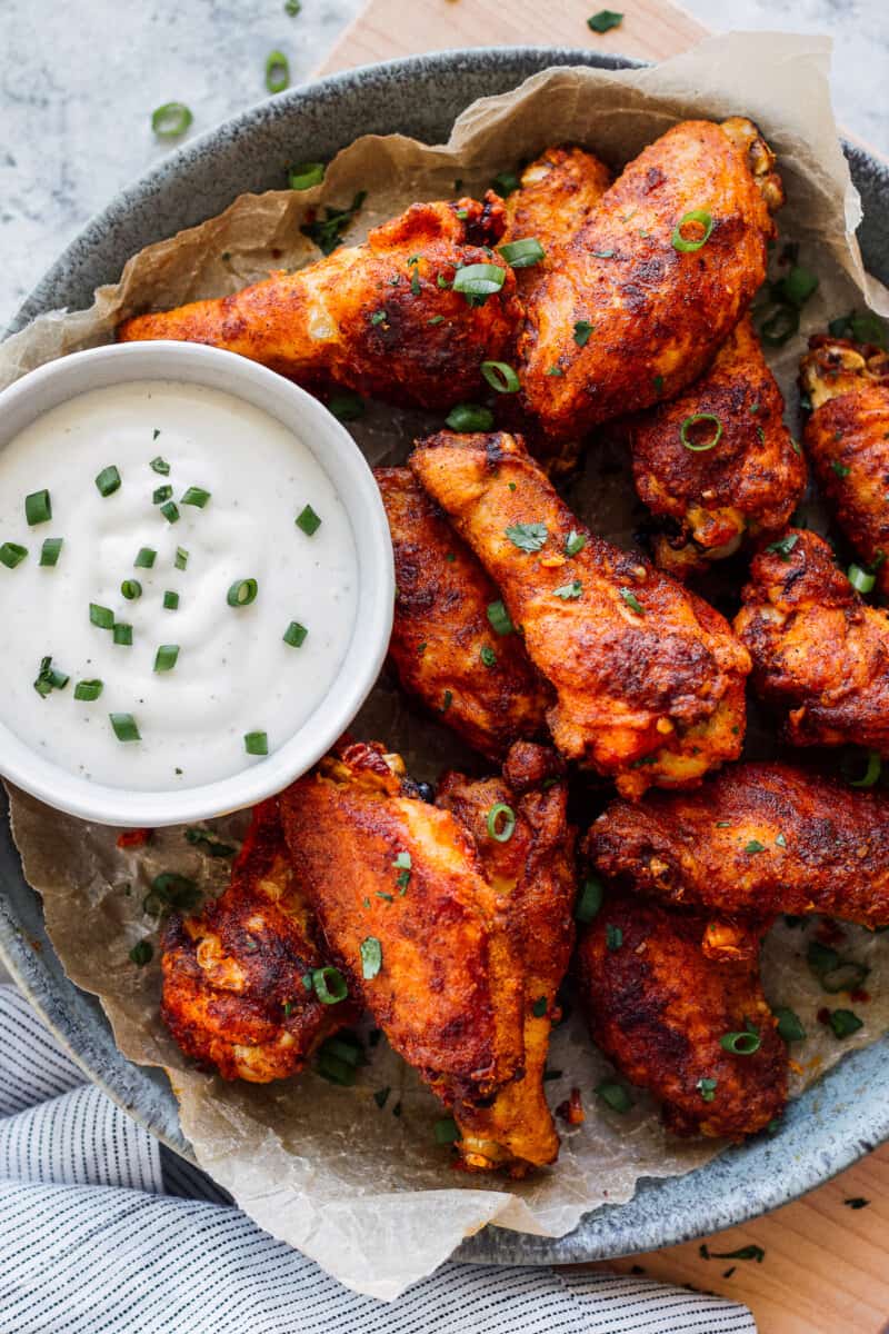 Baked Chicken Wings have the most amazing Chicken Wing Seasoning consisting of paprika, garlic, salt and pepper. If you've wondered How to Bake Chicken Wings that are crispy, flavorful, and amazing, this recipe is for you! EASY Baked Chicken Wings do exist and they're just as delicious, and definitely healthier, when baked and not fried. This is our very favorite Baked Chicken Wings Recipe! platter of baked chicken wings