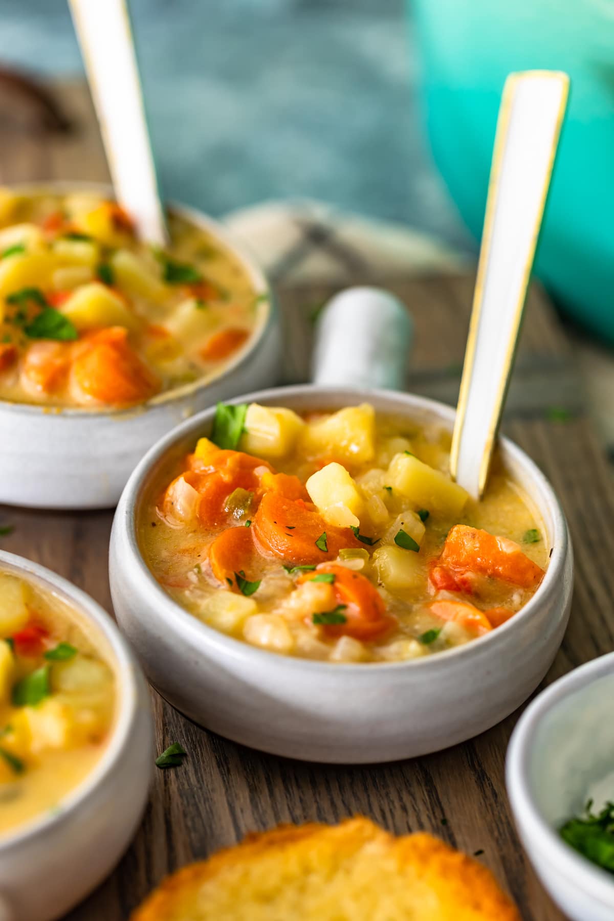 bowls of cheesy soup with vegetables and potatoes