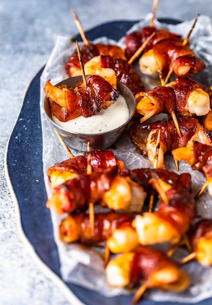 a plate of bacon wrapped shrimp on toothpicks