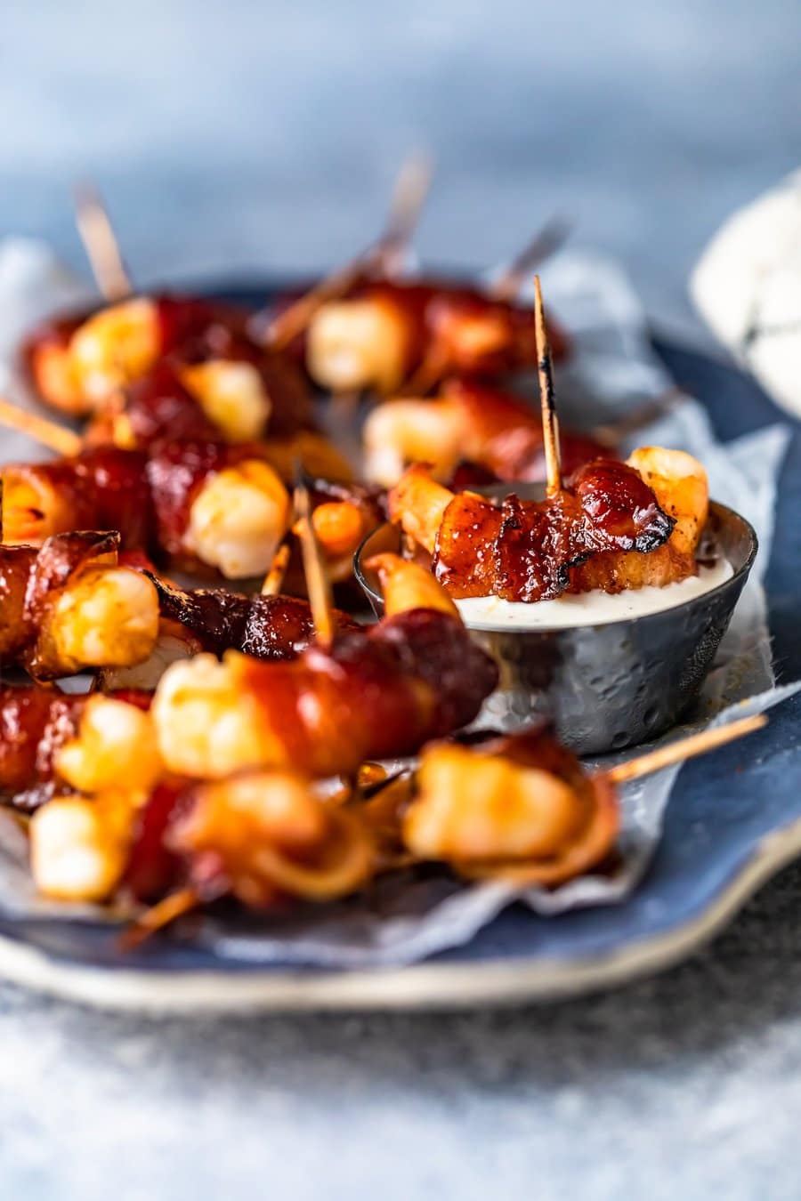 shrimp wrapped in bacon, one dipped in a small bowl