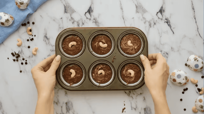 fudge in a muffin tin with cashews on top.