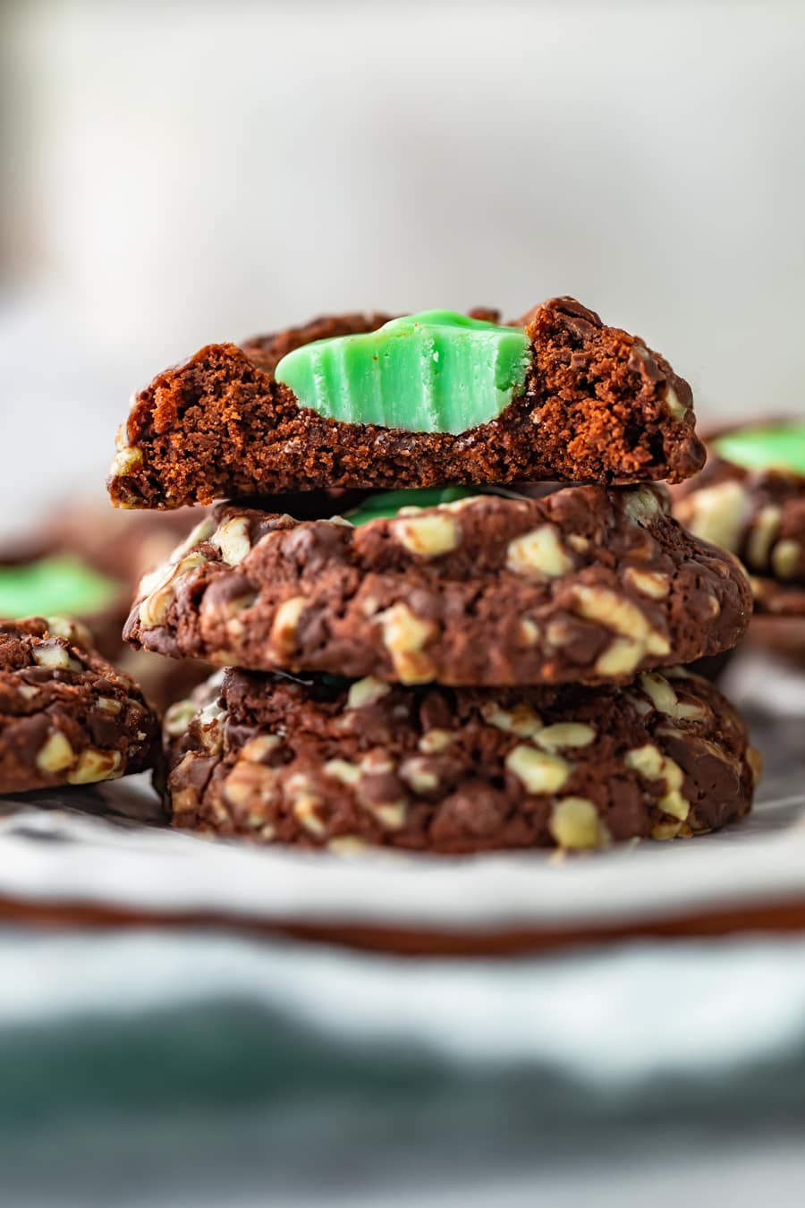 three cookies stacked on top of each other, with a bite taken out of the top one, showing a mint filling