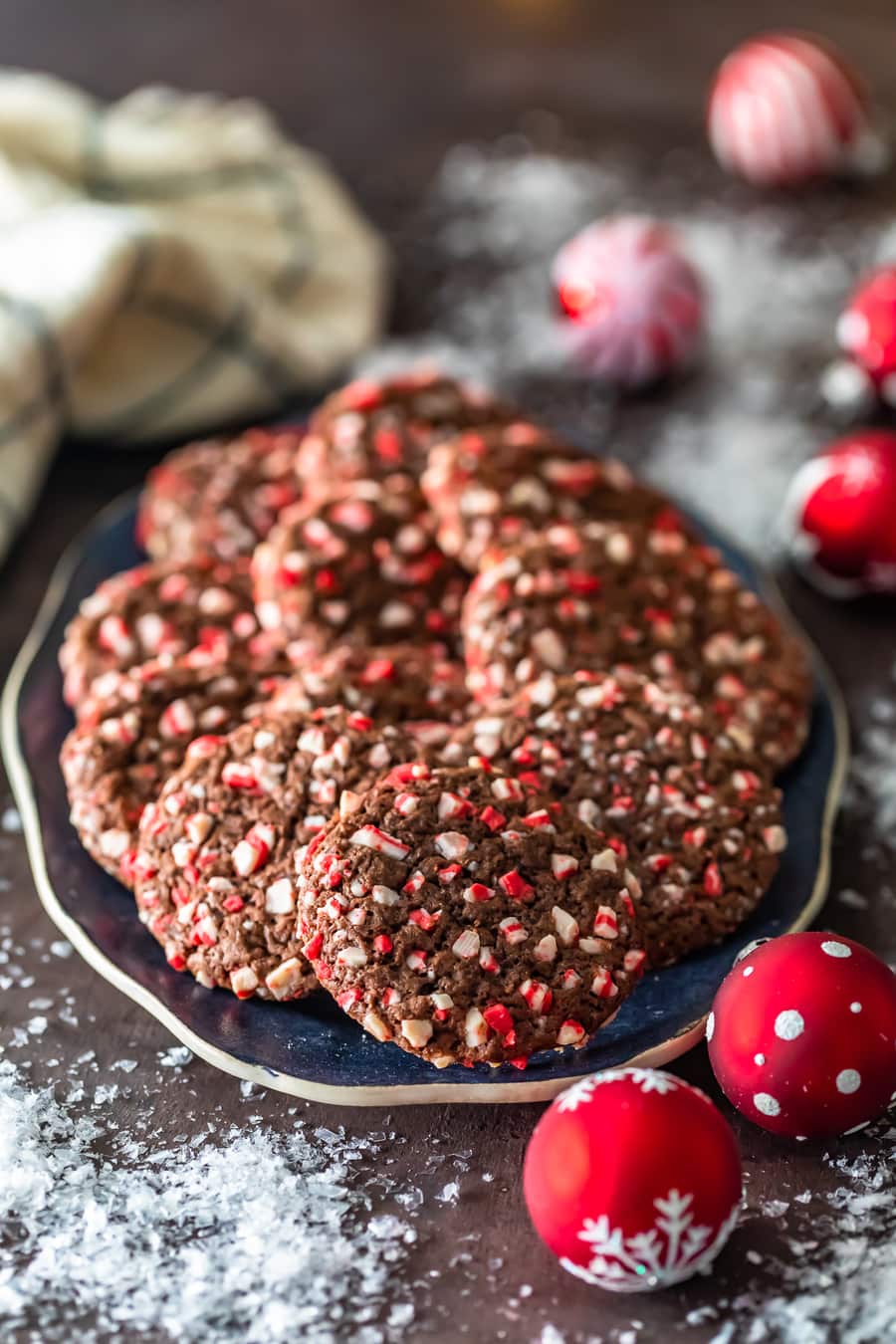 a plate of peppermint chocolate crinkle cookies surrounded by christmas decorations