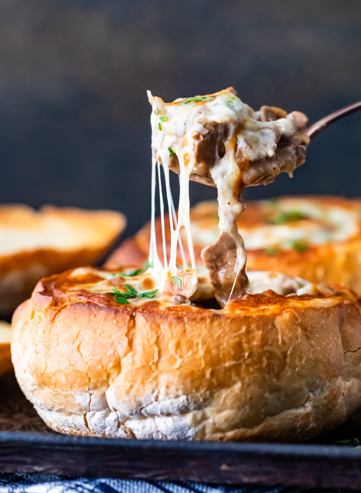 A close up of cheesy soup in breadbowl