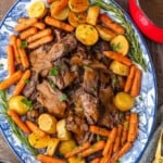 A plate of Christmas pot roast with carrots and gravy.