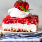 Strawberry Pretzel Salad on a plate with whipped cream and strawberries on top