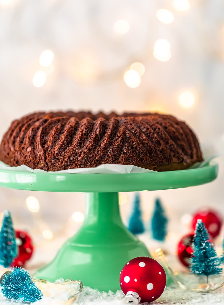 gingerbread cake on a cake stand, with mini Christmas decorations below it