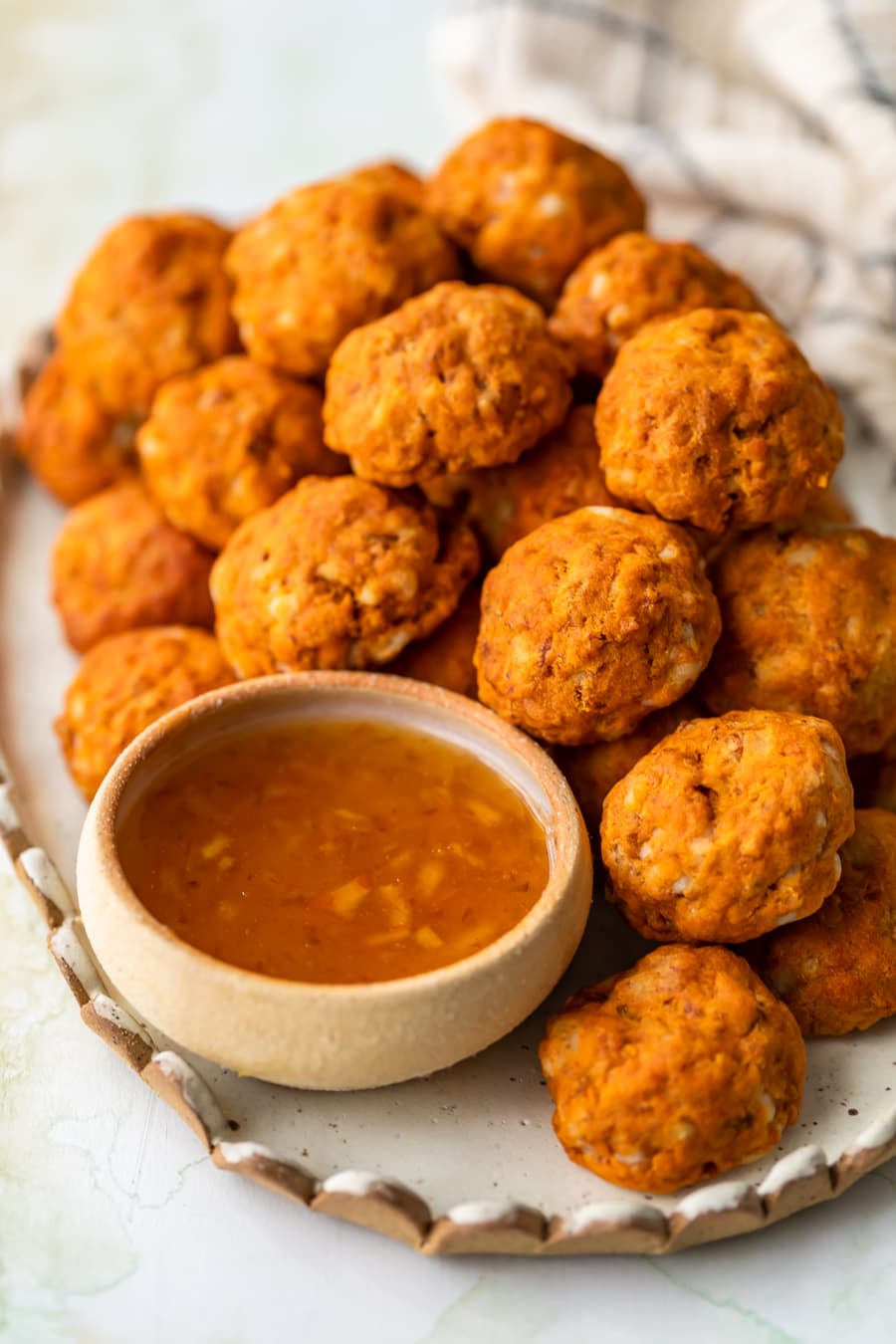 chorizo sausage balls on a serving platter with dipping sauce.