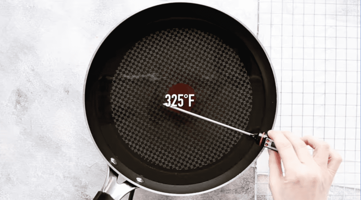 oil in a frying pan with a temperature probe and text that reads "325 degrees fahrenheit".