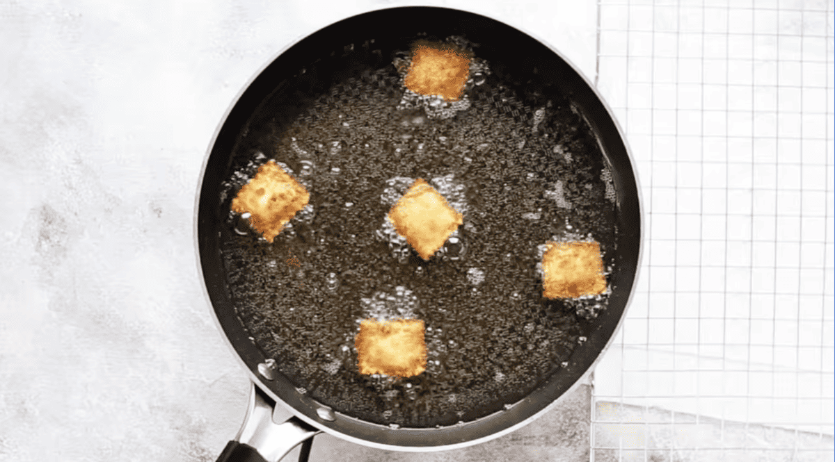 5 ravioli frying in oil.