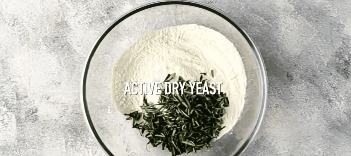 Ingredients to make Dutch oven bread in a glass bowl. 